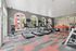 Modern fitness center with treadmills and exercise bikes, featuring large arched windows and motivational word art walls.