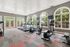 Bright and modern gym with large windows, featuring state-of-the-art cardio equipment and a vibrant atmosphere for an energizing workout.