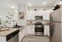 Sleek modern kitchen with stainless steel appliances, elegant white cabinetry, and stylish wall decor, perfect for culinary enthusiasts.