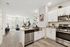 Modern open-plan kitchen and living room with sleek stainless steel appliances and bright natural light.