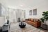 Modern living room with a stylish brown leather sofa, chic artwork, and abundant natural light.