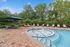 Charming outdoor retreat showcasing a sparkling hot tub surrounded by comfortable lounge seating and lush greenery.