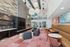 Modern and inviting lobby with vibrant artwork, plush seating, stylish pendant lighting, and a cozy fireplace.
