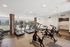 Modern fitness center with state-of-the-art treadmills and exercise bikes, featuring large windows and bright interior design.