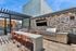 Chic rooftop kitchen with modern appliances, vibrant tile backsplash, and sleek outdoor dining area under a stylish pergola.