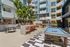 Vibrant outdoor community space featuring a modern BBQ area, lush greenery, pool table, and stylish seating, perfect for social gatherings and relaxation.