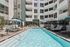 Luxurious apartment complex with a sparkling outdoor pool, comfortable lounge chairs, and stylish cabanas, perfect for relaxation and entertainment.