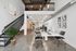 Modern loft-style apartment with sleek industrial design, featuring open workspace with high ceilings and stylish staircase.