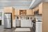 Modern kitchen with sleek stainless steel appliances, elegant tiled backsplash, and light wood cabinetry exuding a warm and inviting vibe.