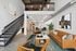 Modern loft showcasing an open-concept living room with cozy seating, stylish decor, and a sleek staircase leading to an upper level.