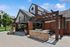Charming outdoor space with a rustic wooden pergola, cozy seating, and a modern grill, perfect for entertaining in a beautifully landscaped community.
