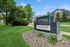 Welcome to Arrive Eden Prairie Luxury Apartments, featuring lush green landscapes and a stylish leasing center sign.