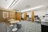 Modern office space with sleek workstations, stylish wooden dividers, and cozy seating areas perfect for productivity.