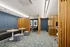 Modern lounge area featuring cozy seating with elegant wooden partitions, stylish blue carpet, and sophisticated wall decor.