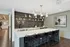 Chic modern kitchen with elegant marble island, stylish pendant lighting, black zigzag tile backsplash, and decorative open shelving creating a sophisticated space.