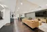 Chic lounge area with comfortable seating, sleek wooden flooring, and a wall-mounted TV, perfect for relaxation and entertainment.