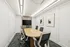 Contemporary conference room featuring a sleek oval table, modern chairs, and a mounted flat-screen TV, perfect for productive meetings.