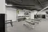 Modern gym with state-of-the-art equipment, including weight racks, benches, and workout stations, under sleek lighting.