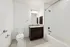 Elegant bathroom with modern fixtures, featuring a granite-topped vanity, sleek bathtub, and stylish tile flooring.