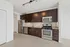 Modern kitchen with sleek stainless steel appliances, dark wood cabinets, and elegant lighting, perfect for culinary enthusiasts.