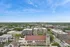 Stunning aerial view of a vibrant cityscape with lush greenery, architectural variety, and a skyline stretching to the horizon under a bright blue sky.