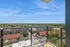 Breathtaking balcony view showcasing vibrant cityscape and lush greenery under a clear blue sky.