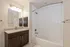 Elegant bathroom showcasing a modern vanity with granite countertop, under-cabinet storage, and a pristine bathtub with sleek fixtures.