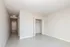 Modern apartment bedroom with neutral tones, sleek tile flooring, and spacious open closet, offering a welcoming and versatile space.