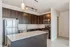 Modern kitchen with sleek stainless steel appliances, elegant dark wood cabinetry, and a spacious granite island countertop.
