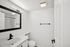 Elegant modern bathroom with sleek fixtures, stylish mirror, and minimalistic design featuring a monochromatic aesthetic.