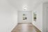 Bright and inviting room with large windows, showcasing elegant wood flooring and a neutral palette, perfect for personalization.
