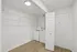 Sleek laundry room with washer, dryer, and ample shelving in a modern apartment.
