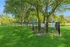 Charming dog park surrounded by lush greenery, featuring a fenced area and informational signs for a delightful pet-friendly experience.