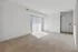 Bright and spacious living area with plush carpeting and sliding glass doors letting in natural light.