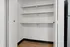 Bright and spacious built-in closet with modern shelving, perfect for organizing essentials in stylish apartment.