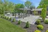 Charming outdoor patio with sleek pergola, modern seating, and built-in grill surrounded by lush greenery.