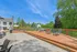 Expansive outdoor deck with comfortable lounge chairs, overlooking lush green space under a clear blue sky.