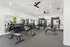 Modern fitness center with state-of-the-art gym equipment and spacious workout area, featuring bright lighting and large mirrors for an energized ambiance.