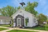 Charming leasing office with classic architecture, surrounded by lush greenery and featuring a welcoming entrance under a clear blue sky.