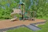 Charming outdoor playground surrounded by lush greenery, featuring a spiral slide and climbing structures for endless fun.