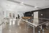 Bright recreational room featuring ping pong and shuffleboard tables with elegant French doors and modern decor.