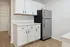 Chic modern kitchen with sleek stainless steel fridge, elegant white cabinetry, and pristine countertops.