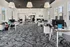 Modern office space with sleek workstations, stylish lighting, and a patterned carpet, designed to inspire productivity and collaboration.