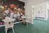 Chic interior showcasing a vibrant floral mural with elegant seating area on lush green carpet, enhancing modern aesthetics.
