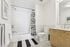 Modern bathroom with sleek white subway tiles, stylish vanity, and a striking black-and-white shower curtain.