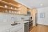 Modern kitchen with sleek appliances, warm wood cabinetry, and inviting open shelving for a stylish culinary space.