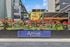Inviting urban entryway with vibrant flower garden and modern signage at Arrive Hollywood.