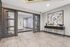Modern apartment lobby with elegant decor, featuring sleek gray doors, abstract art, and stylish console table.