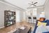 Modern and inviting living room with stylish shelving, elegant ceiling fan, and cozy seating arrangement.