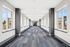 Bright, modern corridor with large windows and stylish carpet design, offering a welcoming ambiance.